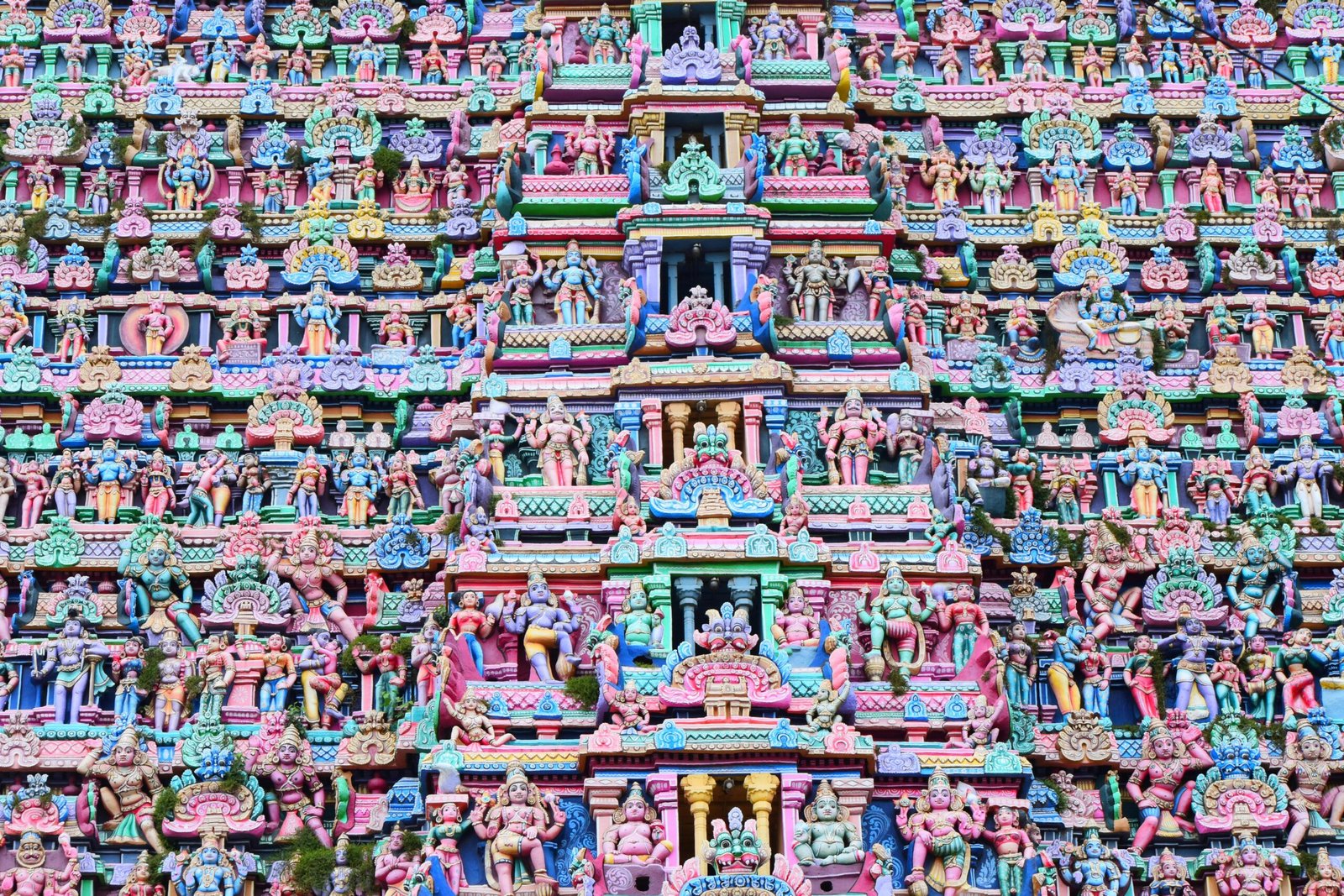 Colorful gopuram architecture displaying vibrant Hindu deities in Kumbakonam, Tamil Nadu, India.