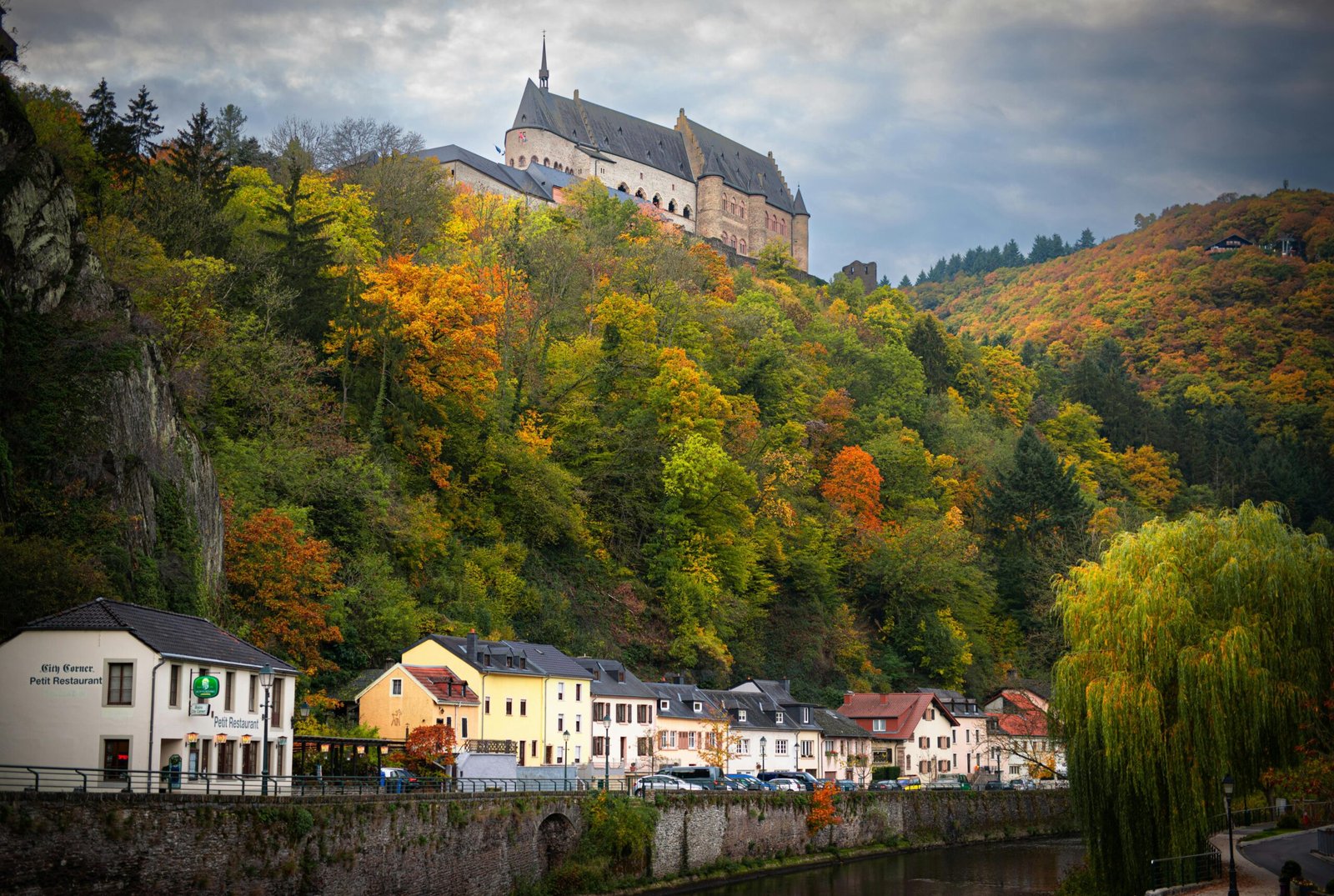 Captivating autumn landscape featuring Vianden Castle and colorful foliage.